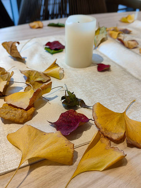 istock Autumn leaves and candle on a table border 2216903656