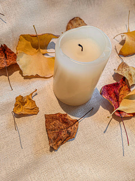 istock Autumn leaves and candle on a table border 2216903662