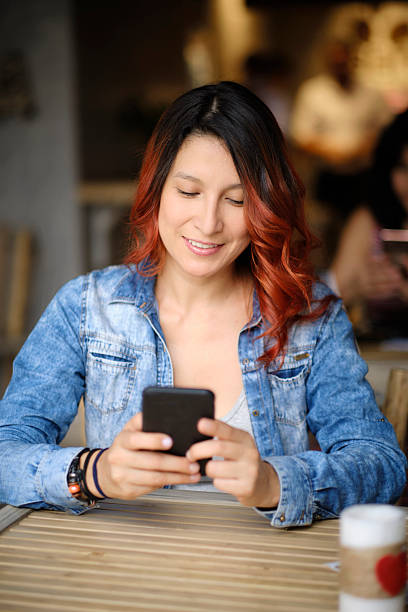istock Young woman using mobile phone in a cafe 2216905366