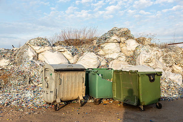 istock Plastic Waste Piles with Sacks and Damaged Green Bin in Foreground 2216907995