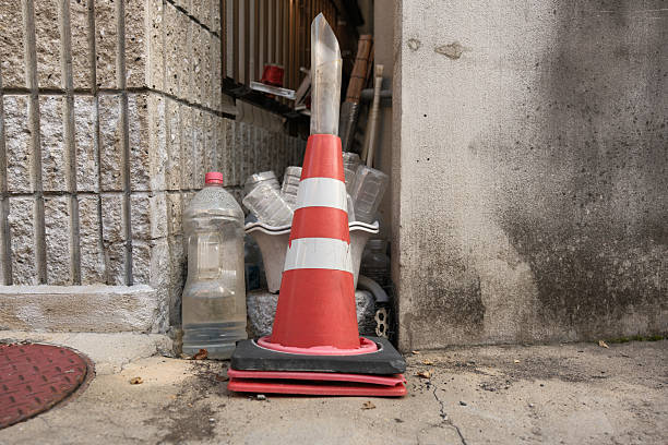 Red and white traffic cone with water bottles behind.
