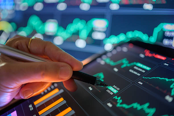 istock hand interacting with trading tablet showing real-time market data and financial chart visualization in investment setup 2216912627