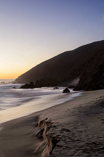 istock Secluded Beach at Sunset with Rocky Shoreline 2216914873