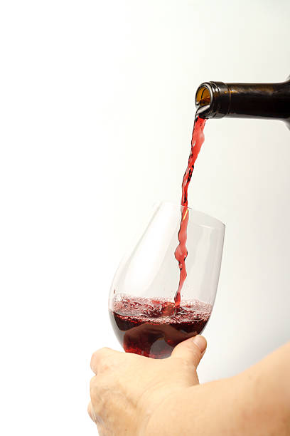 istock Sommelier pouring red wine into glass on white background 2216915948