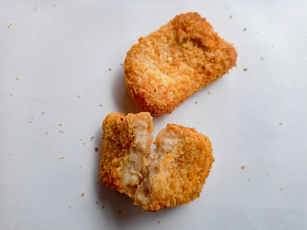 istock Appetizing fried chicken nuggets arranged neatly against a pure white background. 2216915958
