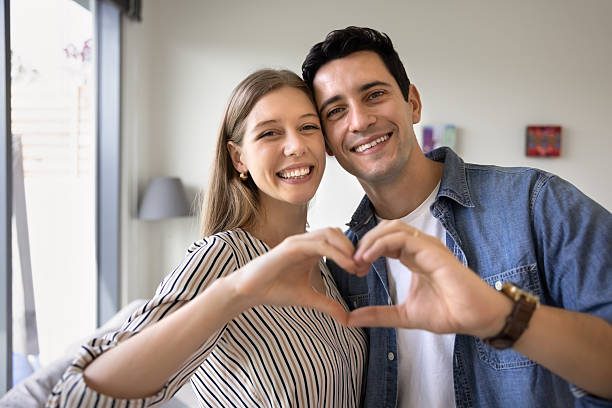 istock Happy attractive young couple making hand heart gesture together 2216917424