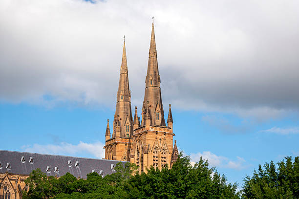 St Paul’s Cathedral in Melbourne, Australia, showcasing Gothic Revival architecture under a bright blue sky.