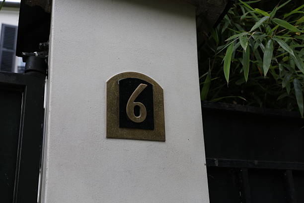 istock Elegant White Pillar with Gold-Numbered Plaque at Entrance Gate 2216919153