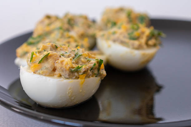 istock Stuffed eggs on a black plate, traditional appetizer with creamy filling, perfect for Easter or festive gatherings. 2216924534