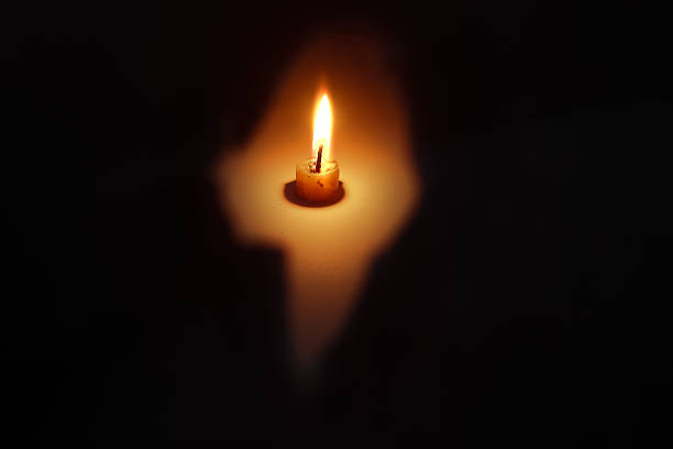 Single Candle Flame Glowing in the Dark