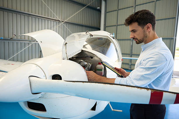 istock Aircraft mechanic inspecting engine with digital tablet in hangar 2216943205