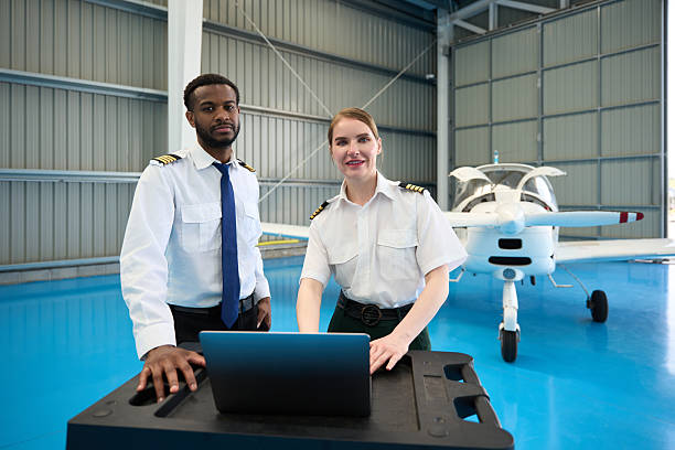 istock Confident student pilots using laptop in aircraft hangar 2216943253