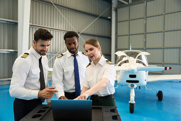 istock Student pilots using laptop in aircraft hangar with small airplane 2216943258