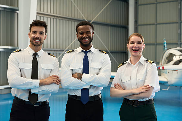 istock Smiling pilots posing with arms crossed in hangar 2216943274