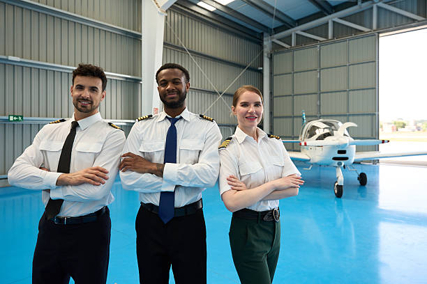 istock Confident student pilots smiling in aircraft hangar 2216943288