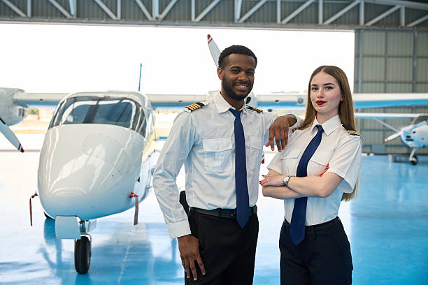 istock Smiling pilot students posing in aircraft hangar 2216943289