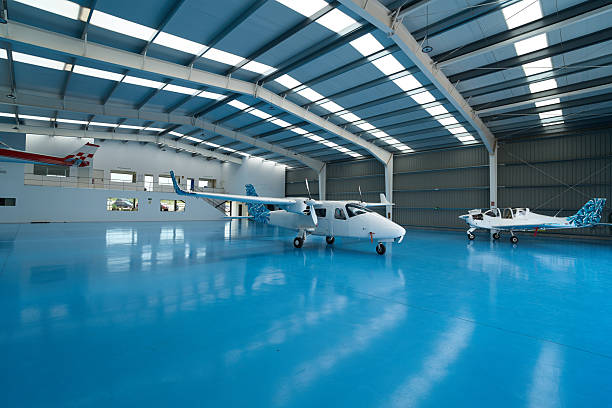 Two light aircraft parked inside an aviation school hangar