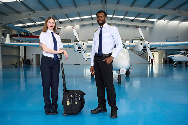 istock Confident student pilots posing in aircraft hangar 2216943624