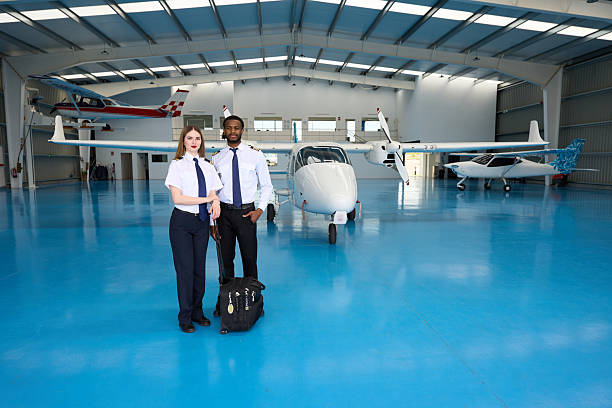 istock Confident student pilots posing in aircraft hangar with light aircraft 2216943641