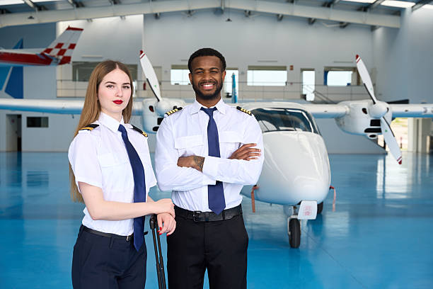 istock Smiling pilot students posing in aircraft hangar with folded arms 2216943642
