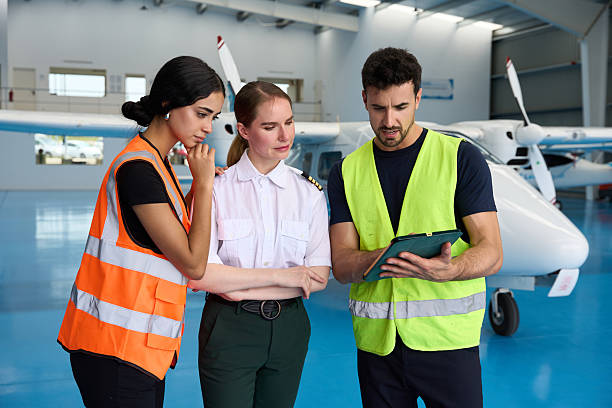 istock Aircraft mechanics and pilot discussing maintenance procedures in hangar 2216943679