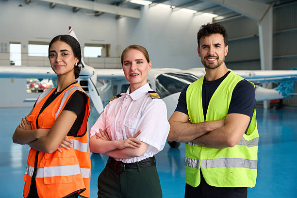 istock Team of aircraft maintenance technicians and pilot posing in hangar 2216943688