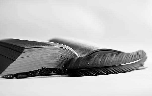 istock an old ink pen and an old book with a white background 2216943703