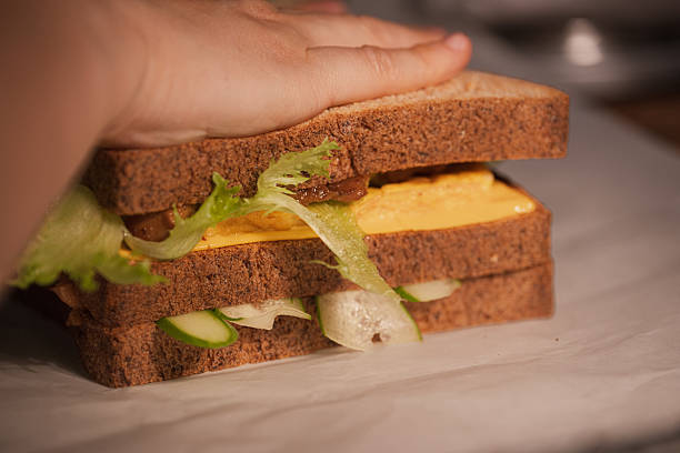 istock Close-up of a Hand Holding a Sandwich 2216943834