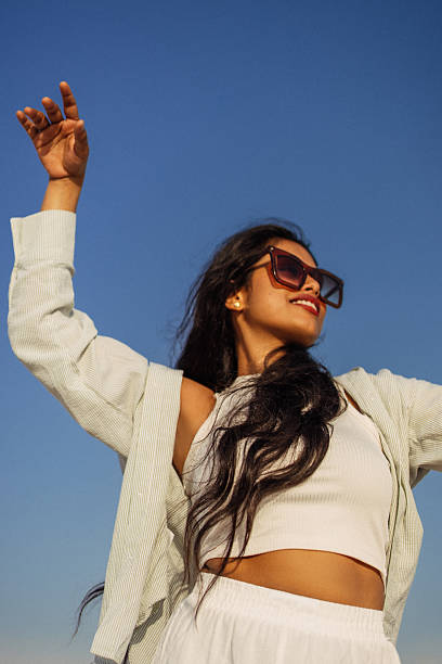 istock Stylish woman enjoying the outdoors under a bright sunny sky 2216944115