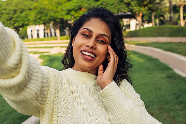 istock Smiling woman outdoors taking a selfie on a sunny day 2216944418