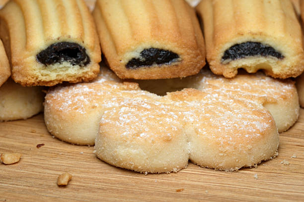 A delightful arrangement of freshly baked treats lies on a rustic wooden surface, featuring golden pastries and soft cookies, inviting all to enjoy their rich flavors and enticing aromas.