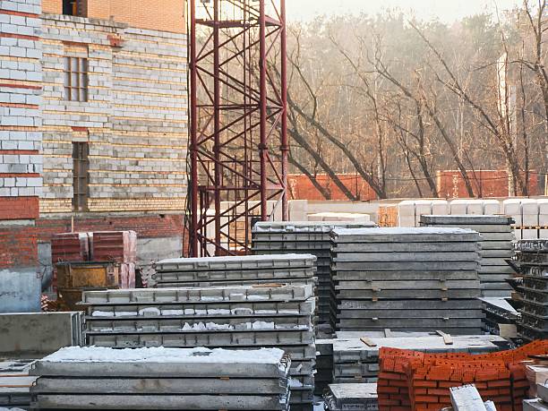 istock A construction site scene featuring stacked concrete slabs, bricks, and a tower crane during winter. 2216946796