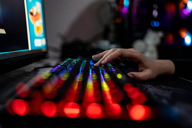 istock Close-Up of Hand Typing on a Colorful LED-Backlit Keyboard 2216946898