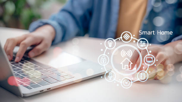 istock Smart home technology concept with person using laptop to control home automation system, showing icons for IoT devices and wireless connectivity in modern lifestyle. 2216952239