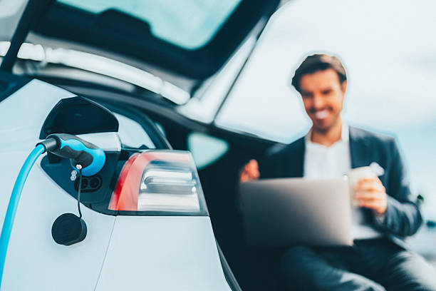 istock Businessman charging electric car while talking on video call 2216954689