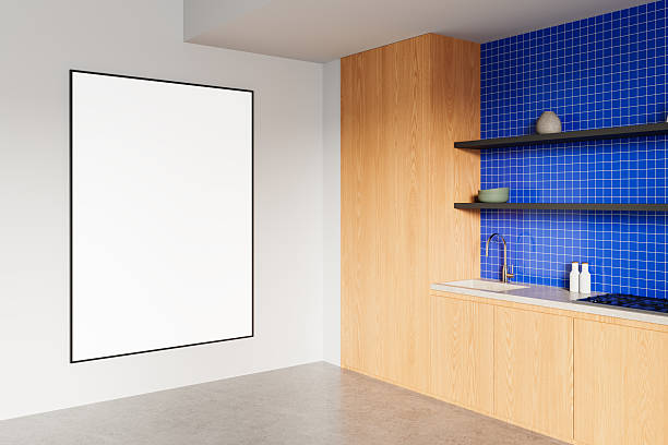 istock Blank framed poster mockup on clean white wall next to modern kitchen with wood panels and blue tiled backsplash, minimalist interior concept. 3D Rendering 2216955570