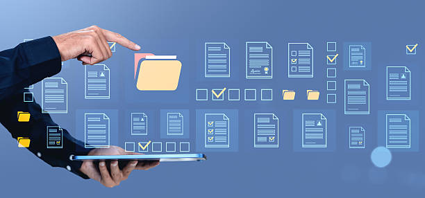 istock Digital document management concept with hand pointing at virtual folder icons on blue background. 2216955986
