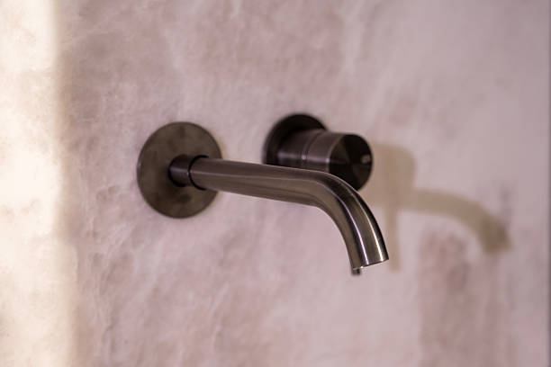 istock Modern stainless wall-mounted faucet on light marble surface 2216957414