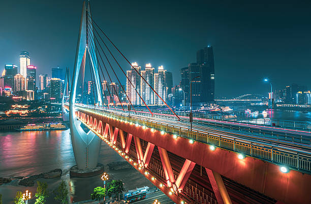 istock Modern cable-stayed bridge illuminated against the city skyline with bright lights reflecting on the river at night in Chongqing, China. 2216959327