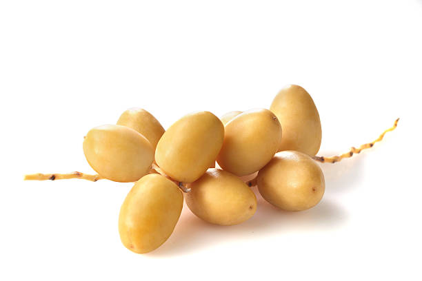 istock Fresh yellow date palm fruit isolated on white background with clipping path. Sliced cut cha la dates fruits with leaf branch 2216961949