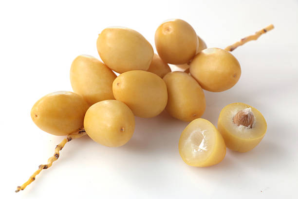 istock Fresh yellow date palm fruit isolated on white background with clipping path. Sliced cut cha la dates fruits with leaf branch 2216961972