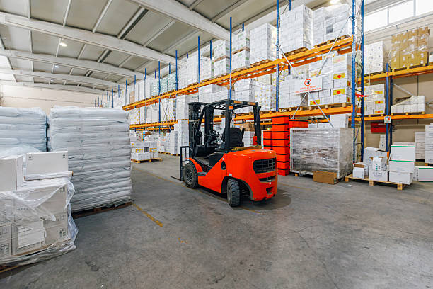 istock Industrial Red Forklift in Spacious Warehouse Aisle with Stacked Goods and Pallets 2216964813