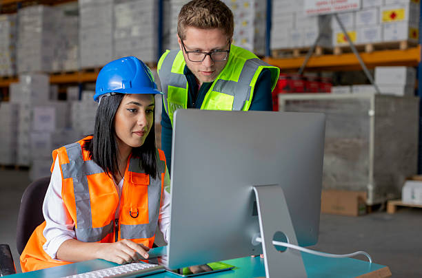 istock Young Male and Female Warehouse Workers Collaborating on a Computer in a Warehouse 2216964815