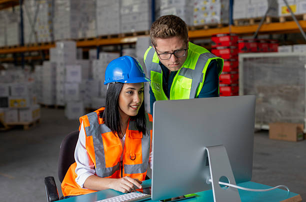 istock Young Male and Female Warehouse Workers Collaborating on a Computer in a Warehouse 2216964823