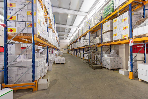 istock Empty Warehouse Aisle with Shelves Stacked with Boxes and Staircase for Access 2216964869