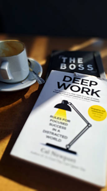 Deep work book, coffee cup, and the boss notebook symbolize focus and productivity in modern workspace