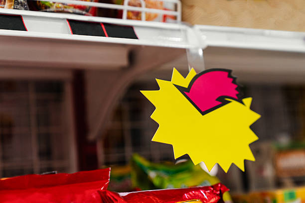 A vivid yellow starburst-shaped price tag with a pink arrow attached to a store shelf — ideal for drawing attention to promotional items or discounts in a retail setting.