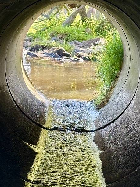 istock View through concrete tunnel carrying a stream under a bridge 2216972190