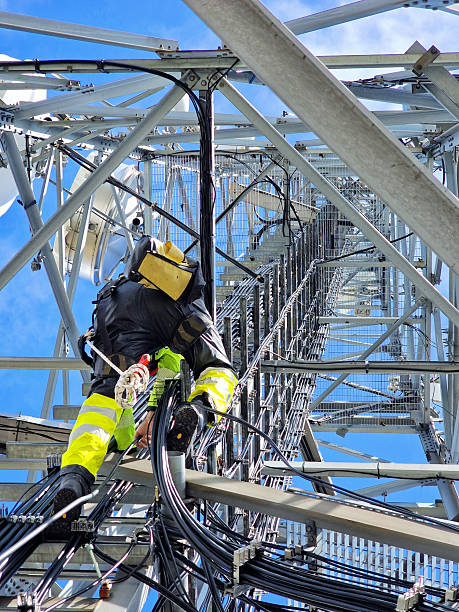 istock Engineer utility infrastructure worker at big steel mast working with radio link 2216973767