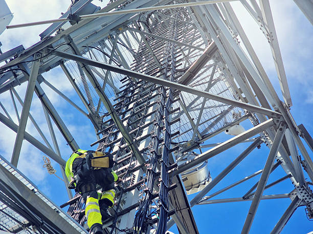 istock Engineer utility infrastructure worker at big steel mast working with radio link 2216973836